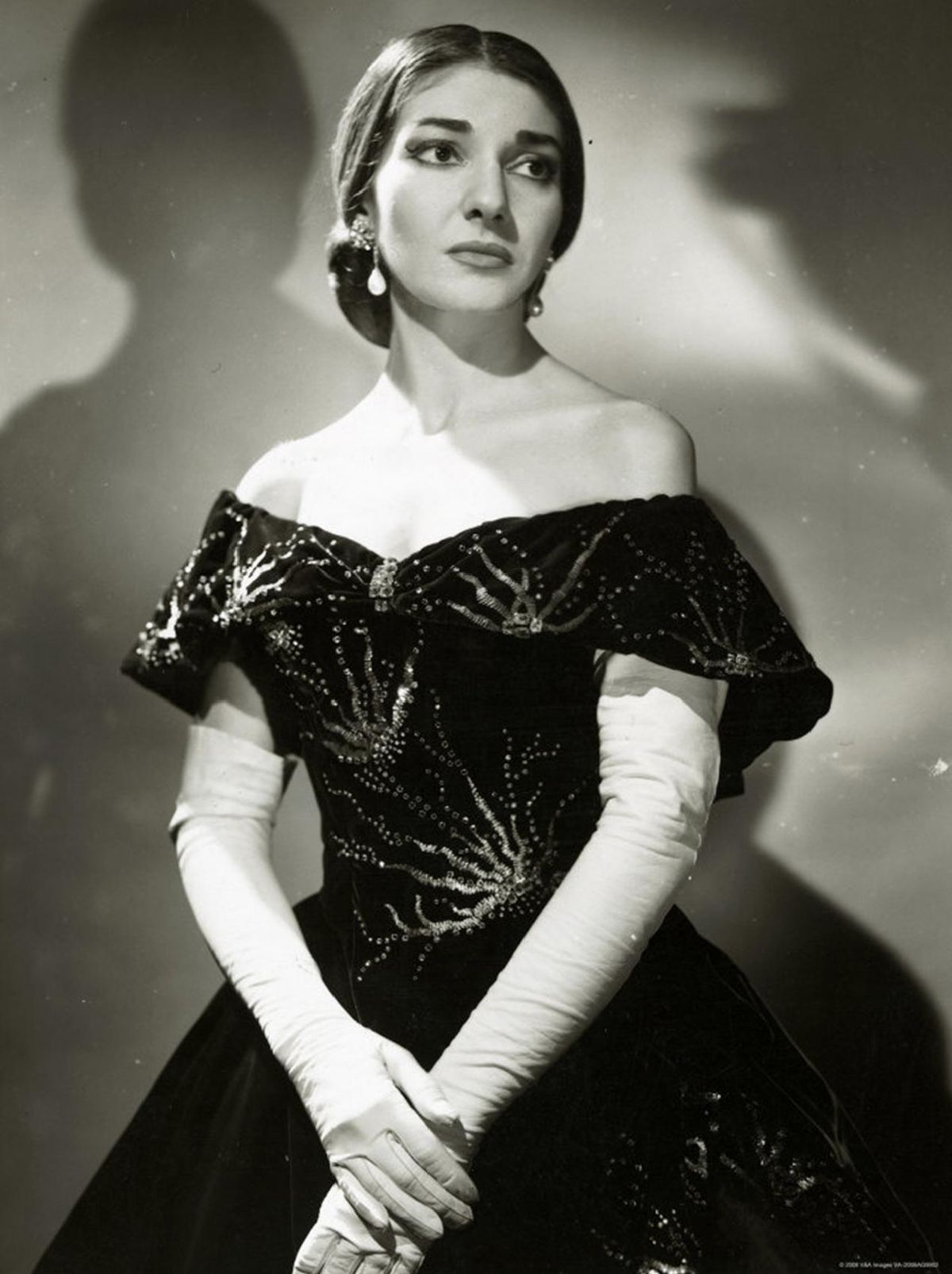 Retrato en blanco y negro de María Callas posando angustiada con con vestido levemente escotado.