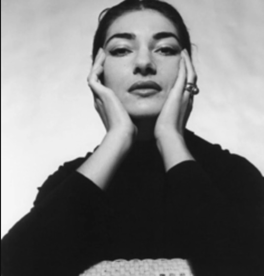 Retrato en blanco y negro de María Callas tocándose las mejillas con sus manos.